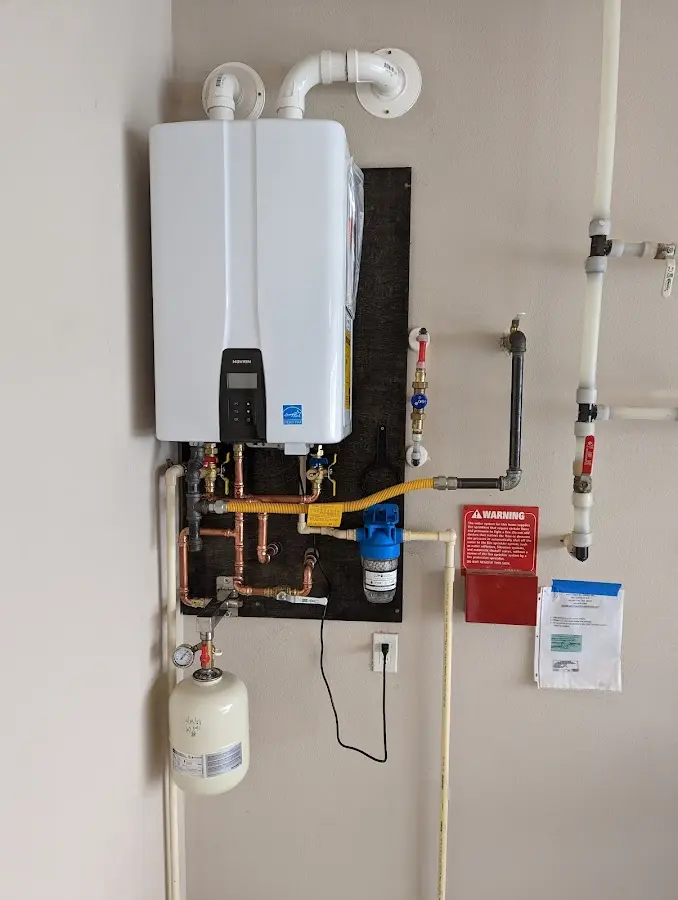 Professional plumber installing copper piping in a Roxbury home